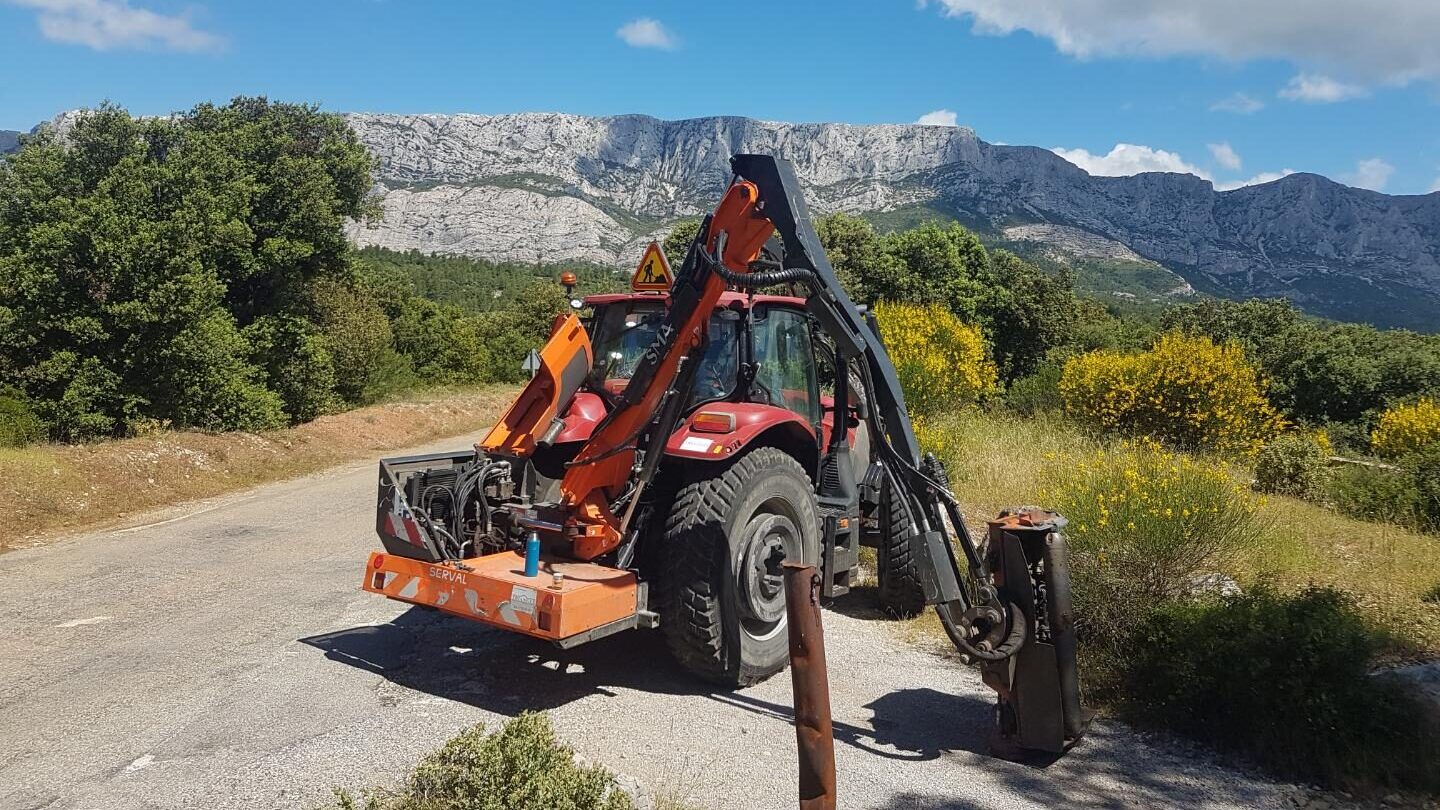 Le tracteur et son épareuse sur une petite route, devant la montagne Sainte-Victoire